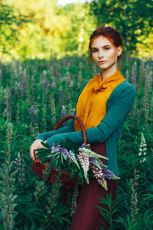 portrait of a beautiful girl with brown hair among the flowers in the field. summer holiday with flowers.の写真素材