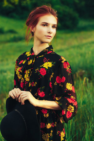 portrait of a beautiful girl with brown hair among the flowers in the field. summer holiday with flowers.の写真素材