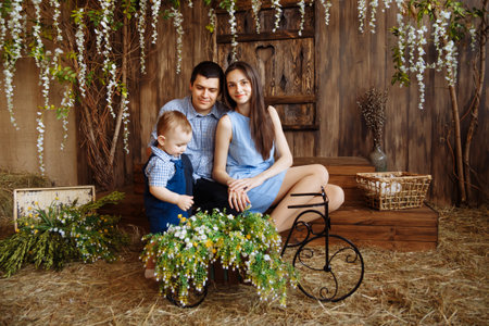 family in the village, with rabbits in their arms. little boy with mom and dad. white rabbitsの写真素材