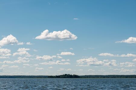 Beautiful summer lake, on  background of forest and cloudy sky.の写真素材