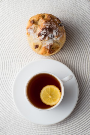 Homemade carrot muffin with cap of tea and lemon on white fabric background. top viewの写真素材