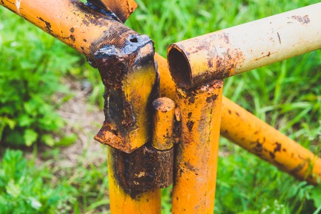 old rusty yellow pipe on a background of green grass.の写真素材