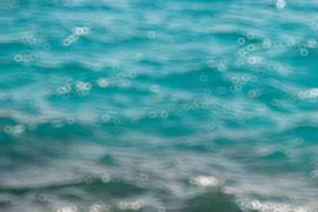 Photo closeup of beautiful clear turquoise sea ocean water surface with ripples low waves on seascape, Blurred bokeh background.の写真素材