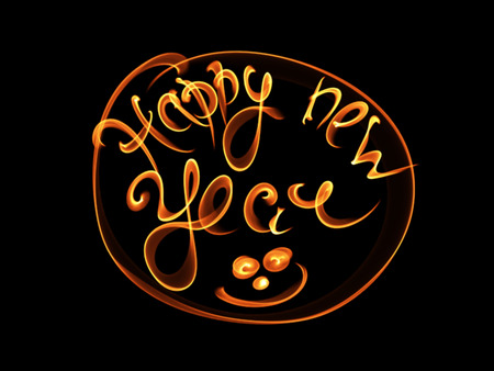 Happy new year isolated words lettering written with fire flame or smoke on black background.の写真素材