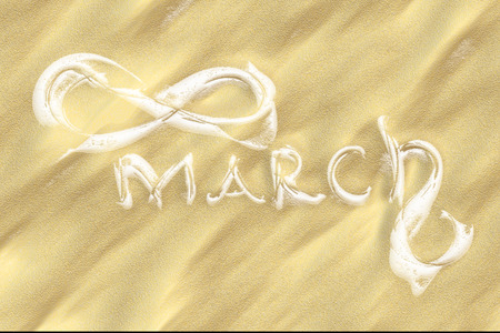 March 8 greeting card. Background for International Womens Day. Lettering made by ivory in the desert sand, creative conceptの写真素材