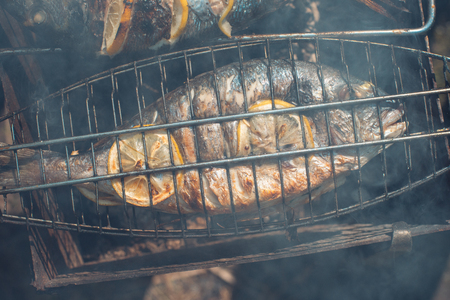 Grilled fish with lemon on the grid Barbeque in the garden in summer.の写真素材