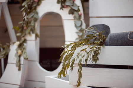 A lot of white painted wooden cage boxes, some with decorative candles, rolled blankets and domestic plantsの写真素材