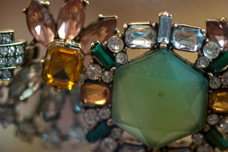 Bracelet with green and pale orange blue stones macro shot