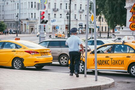 MOSCOW, RUSSIN FEDERATION - JULY 28, 2017: The inspector policeman stopped Yandex taxi driver, in Moscow in Russia during summer season - Imageのeditorial素材