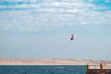 professional kiter glide the water surface of the ocean at great speed. Back view behind extreme...