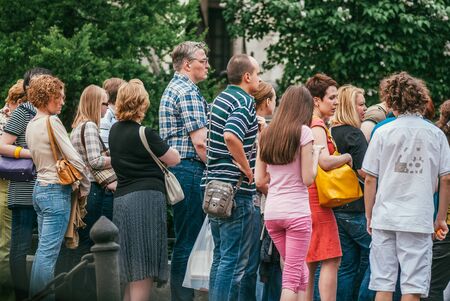 Moscow, Russia - May 15, 2010: A group of people in colorful clothes of different ages stand in line...