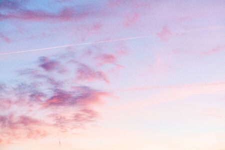 Evening sunset sky with bright rays of the sun and beautiful colorful clouds