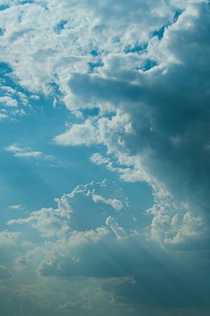 Evening sunset sky with bright rays of the sun and beautiful colorful clouds