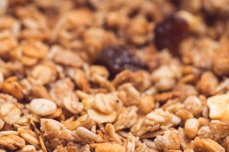 Useful and tasty muesli with nuts, rasins and flakes. Selective focus macro shot with very shallow depth of field. Healthy and vegetarian lifestyleの写真素材