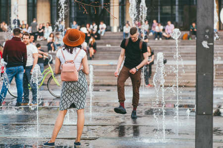 Moscow, Russia - may 1, 2018. Active people in the city. Young man, woman wear skirt and other people enjoing in a city fountainのeditorial素材