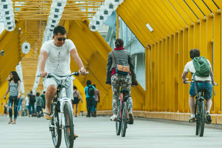Moscow, Russia - JUNE 1, 2014: Young couple and man on bicycles cross the Bogdan Khmelnitsky pedestrian bridgeのeditorial素材