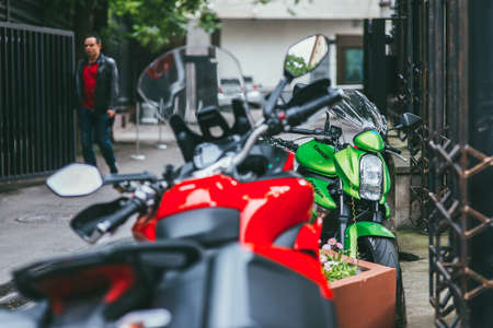 Moscow, Russia - JULY 7, 2017: Green Kawasaki er-6n motorcycle is strapped to a metal fence next to a red motorcycle Selective focus macro shot with shallow DOFのeditorial素材