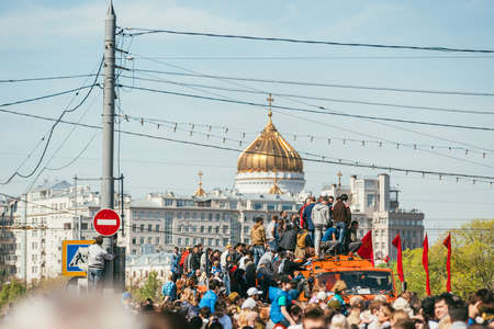 MOSCOW, RUSSIA-MAY 09, 2015: People celebrate Victory Day May 9 in Bolshoy Moskvoretskiy Most. People climb on an orange truck in the background of the Church of Christ the Savior. A lot of people with the Ribbons of Saint Georgeのeditorial素材