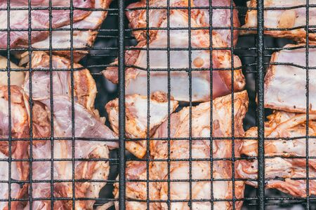 Tasty Grilled pork ribs on the grill barbecue at the start of the cooking process. top closeup view. under bright summer sun.の写真素材