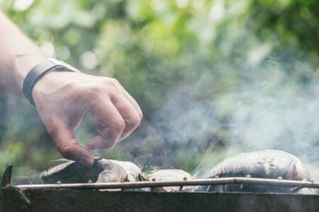 male hand check readiness of stuffed fresh and raw fish.の写真素材