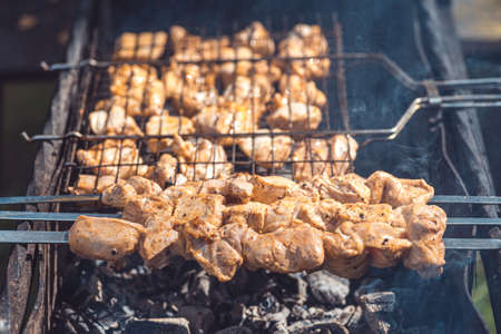 barbecue cooked on coals, under the rays of the summer sunの写真素材