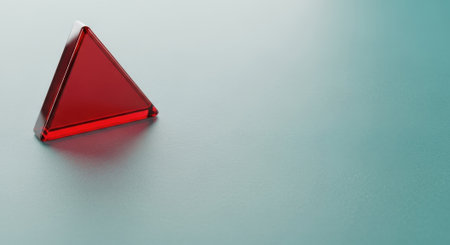 A captivating close-up of a vibrant red geometric pyramid, showcasing its glossy surface and subtle reflections against a neutral backdrop.の素材