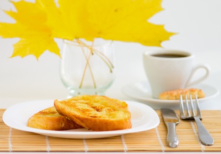 Coffee cup and sweet toast with autumn leaves on white backgroundの写真素材