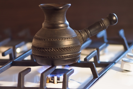 Ceramic pot with coffee on cooking on gas fireの写真素材