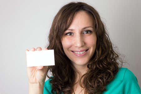Young smiling woman with blank card in handの写真素材