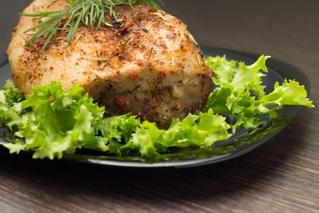 Baked Meat in Black Dish on Dark Wooden Table with Green Saladの写真素材