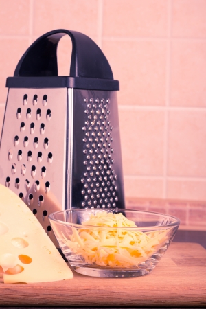 Grated Yellow Cheese with Grater at the kitchen. Toned Imageの写真素材