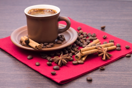 Cup of Coffee with Beans and Spices on Red Napkinの写真素材