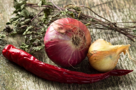 Onion and Red Chilli Pepper with herbs on old wood boardの写真素材