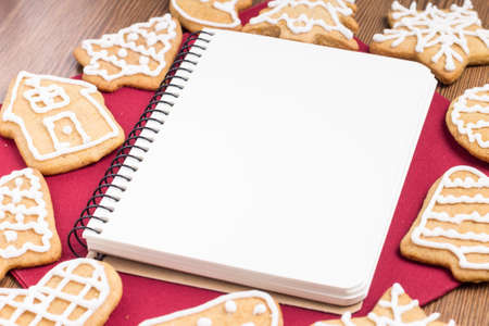 Empty white notebook with gingerbread cookies aroundの写真素材