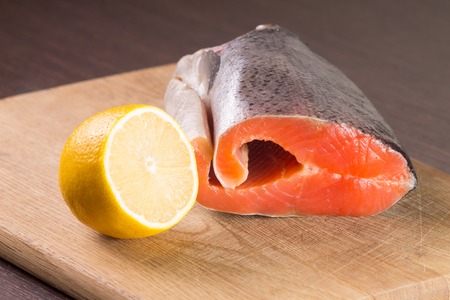 Fresh Raw Salmon or Trout with Lemon on woodの写真素材