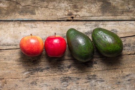 Two avocado and two apples on rural wooden backgroundの写真素材