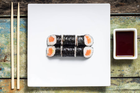 Makisushi on white plate. Seafood traditional maki sushi rolls with chopsticks. Top Viewの写真素材