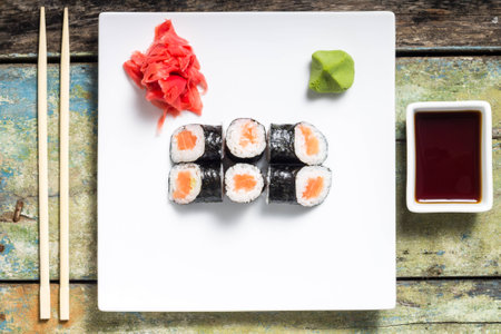 Makisushi on white plate. Seafood traditional maki sushi rolls with chopsticks. Top Viewの写真素材