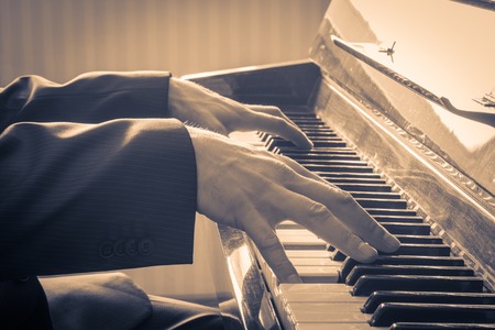 Man's hands playing the Piano.  Retro Style. Warm color tonedの写真素材
