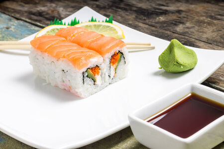 Seafood sushi rolls in white plate with chopsticks and japanese spicesの写真素材