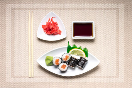 Seafood Maki-sushi rolls in white plate with chopsticks and japanese spices. Top Viewの写真素材