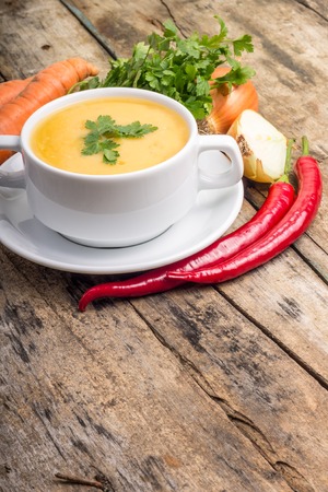 Organic food. Pea soup with vegetables around on wood backgroundの写真素材