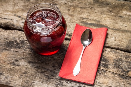 Strawberry jam with teaspoon served on wood backgroundの写真素材