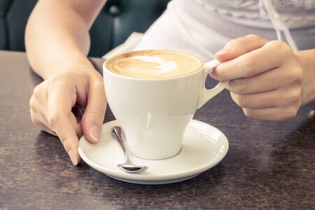 Morning coffee. Cup of Cappuccino in Cafe. Warm color toned imageの写真素材