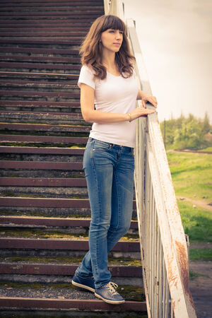 Girl standing at the stairs. Young woman waiting forの写真素材