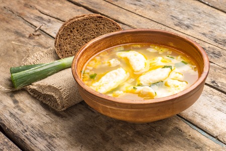 National ukrainian soup with galushky. Soup with dumplings in ceramic homemade bowl.の写真素材