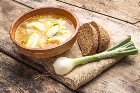 National ukrainian soup with galushky. Soup with dumplings in ceramic homemade bowl.の写真素材
