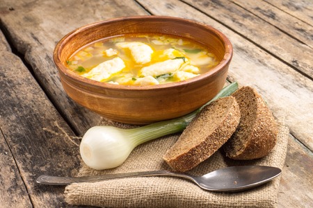 National ukrainian soup with galushky. Soup with dumplings in ceramic homemade bowl.の写真素材