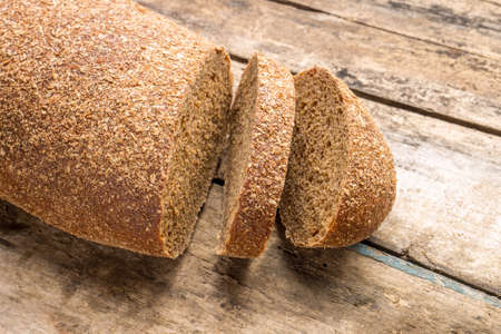 Rye bread laying on the old wood table.の写真素材