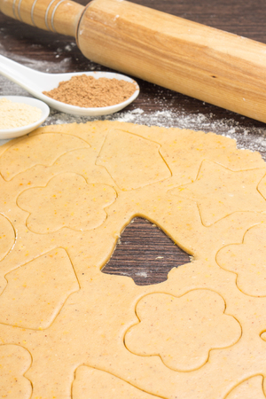 Rolled out gingerbread dough with cutting shapes of christmas decorationの写真素材